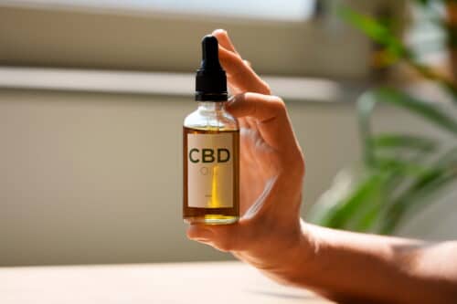 close up woman holding cbd oil (1)