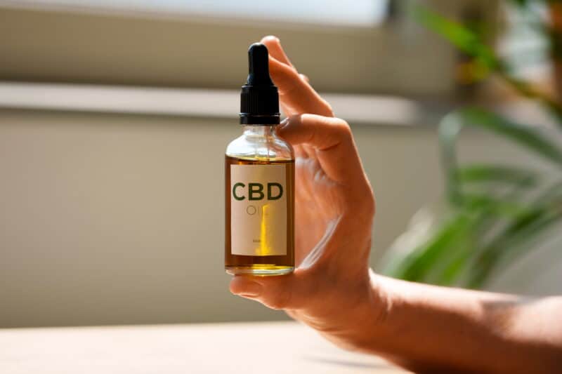 close up woman holding cbd oil (1)