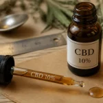 Huile de cbd 10 effet : pipette et flacon CBD 10% sur table bois clair